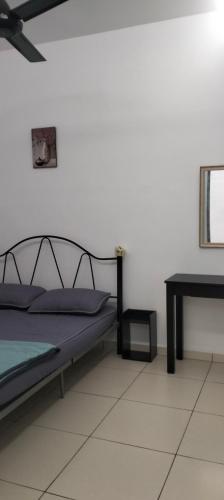 Un dormitorio con una cama y una mesa en una habitación. en Nice House At Alor Gajah near UITM UTEM, en Kampong Ulu Melaka Pindah