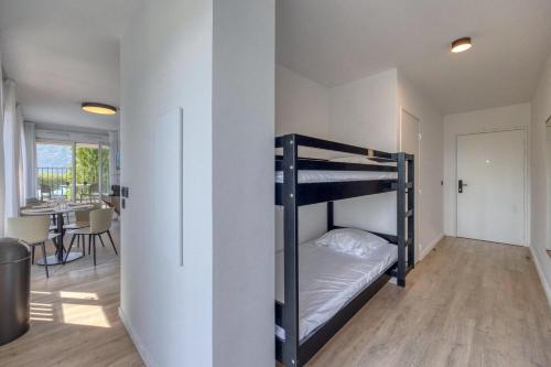 a bedroom with bunk beds and a dining room at KOSY APPART'HÔTELS - Résidence du Lac in Aix-les-Bains