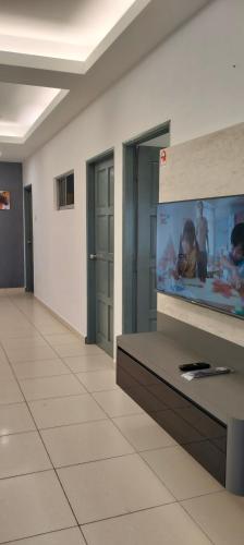 Una habitación con un televisor de pantalla plana en una pared. en Nice House At Alor Gajah near UITM UTEM, en Kampong Ulu Melaka Pindah