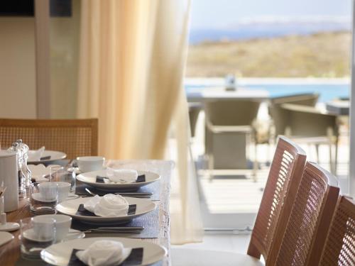 a table with plates and bowls on top of it at Absolute Paradise Santorini in Akrotiri