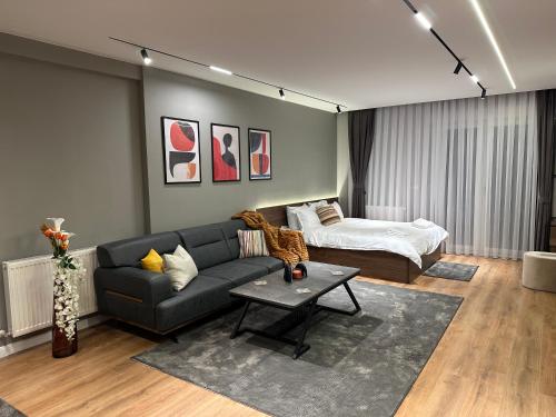 a living room with a couch and a bed at Aparte - Tophane in Pristina