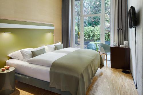 a bedroom with a large white bed and a window at Wedina Budget in Hamburg
