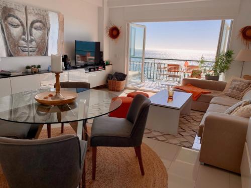 a living room with a glass table and a view of the ocean at Beachfront Apartment In Fuengirola in Fuengirola