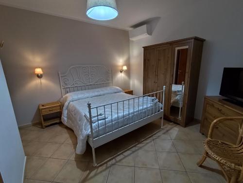 a bedroom with a bed and a tv and a chair at Villa Cristina in Pontelatone