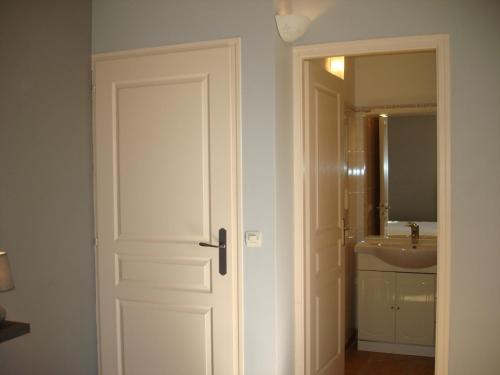 una puerta que conduce a un baño con lavabo en house in the countryside in the luberon with beautiful view and private swimming-pool close to bonnieux in Provence - 8 personnes, en Bonnieux