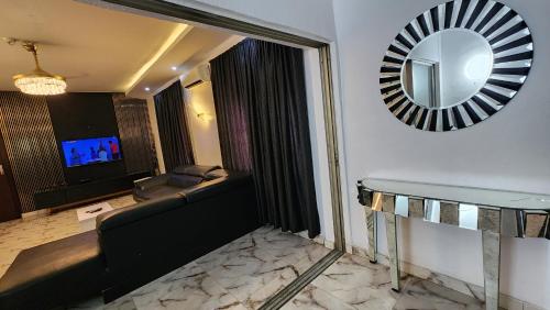 a living room with a couch and a mirror at CG Apartments in Ikeja