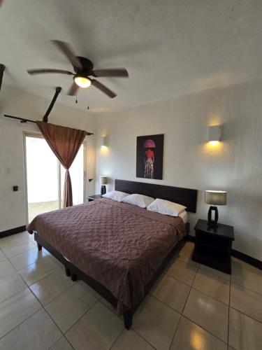 a bedroom with a bed with a ceiling fan at Hotel Villa Capricho in Ciudad Madero