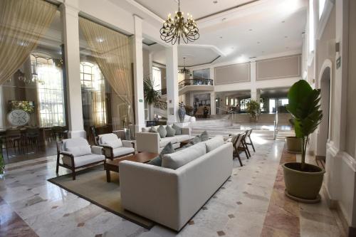 a lobby with couches and chairs in a building at Plaza Camelinas Hotel in Querétaro