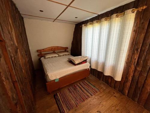 a small bedroom with a bed and a window at Cabañas Morito Pichilemu in Pichilemu