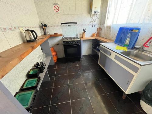 a small kitchen with a sink and a stove at Cabañas Morito Pichilemu in Pichilemu
