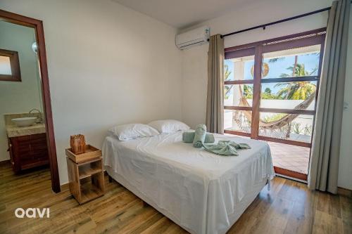 Un dormitorio con una cama y una ventana grande en Qavi - Casa Palm Paradise #ParaisoDoBrasil, en Touros