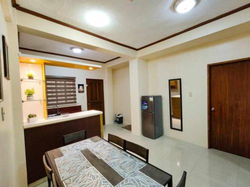 a dining room with a table and a refrigerator at Spacious Apartment near Evia Daang Hari in Manila