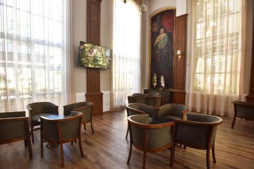 a waiting room with chairs and tables and windows at Plaza Camelinas Hotel in Querétaro