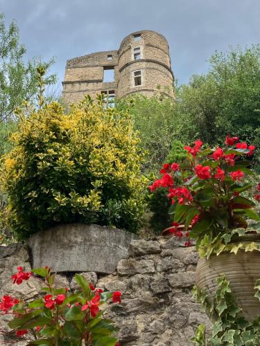 a building with red flowers on a stone wall at Chateau appartement tussen Mont Ventoux en Luberon in Montbrun-les-Bains