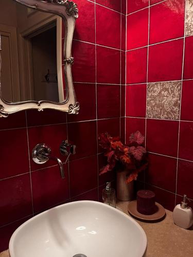 a bathroom with a white sink and red tiles at The Monna Lisa Resort in Arezzo