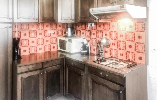 une cuisine avec une cuisinière et un micro-ondes dans l'établissement Cozy Home In La Tranche-Sur-Mer, à La Tranche-sur-Mer