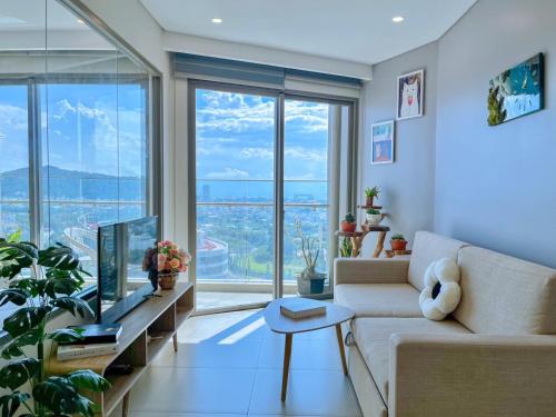 a living room with a couch and a large window at The Song Boutique Apartment in Vung Tau