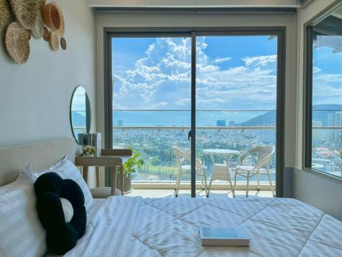 a bedroom with a bed and a large window at The Song Boutique Apartment in Vung Tau