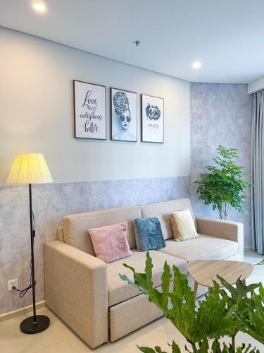 a living room with a couch and three pictures on the wall at The Song Boutique Apartment in Vung Tau