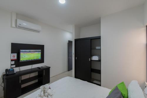a bedroom with a bed and a flat screen tv at Apartamentos La Casona in Fortuna