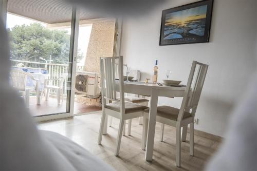 Cette chambre dispose d'un balcon avec une table et des chaises blanches. dans l'établissement Maresol, à Cagnes-sur-Mer