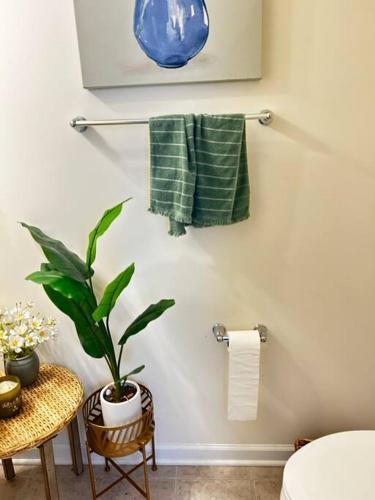 a bathroom with a plant and towels on a wall at Luxury Beautiful Spacious Retreat Getaway in Columbus
