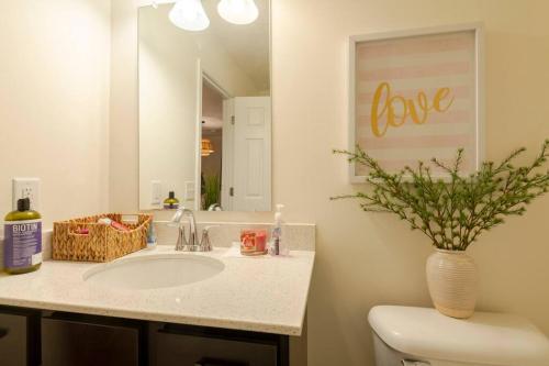a bathroom with a sink and a vase with love on the mirror at Luxury Beautiful Spacious Retreat Getaway in Columbus
