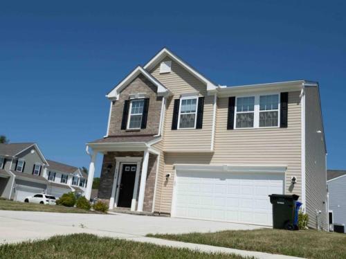 a brown house with a white garage at Luxury Beautiful Spacious Retreat Getaway in Columbus
