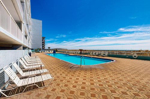 a group of lounge chairs sitting next to a swimming pool at Islander W 703 in Fort Walton Beach