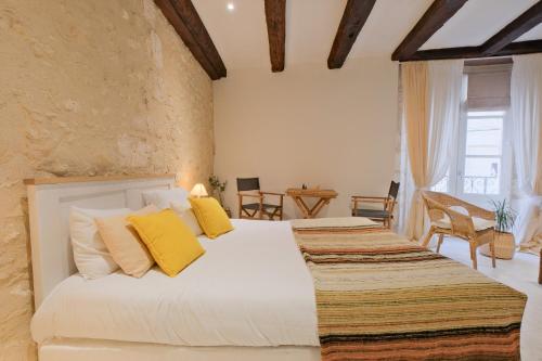 a bedroom with two beds with yellow pillows at Gite d'ici et d'ailleurs in Brantôme