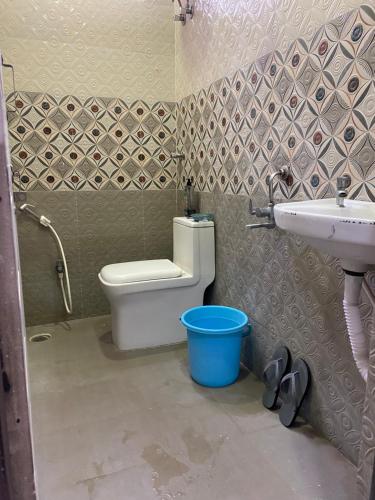a bathroom with a toilet and a sink and a bucket at SRT HOMELY STAY WITH All AMENITIES in Hyderabad