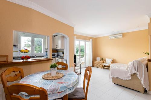 a kitchen and living room with a table and chairs at Yourhouse El Xiprer in Pollença