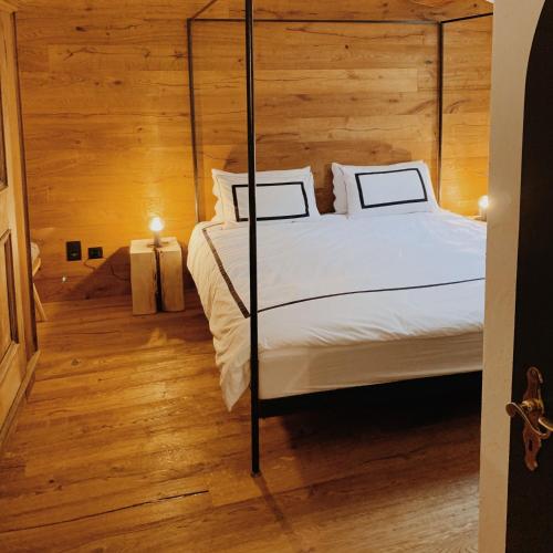 a bedroom with a four poster bed and wooden floors at Apartment Euforia in Samedan