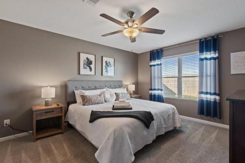 Un dormitorio con una cama y un ventilador de techo. en New Bama Retreat Sleeps 8, en Tuscaloosa