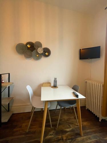 - une table et des chaises blanches dans la chambre dans l'établissement Rubis 1, à Vichy