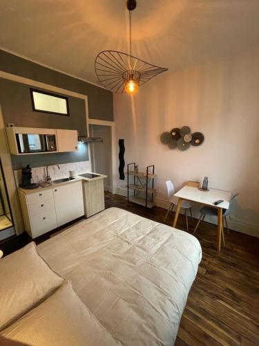 une chambre avec un grand lit et une table dans l'établissement Rubis 1, à Vichy