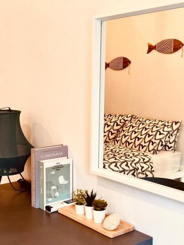a mirror on a wall next to a table with a clock at P Vacation Libong in Ko Libong