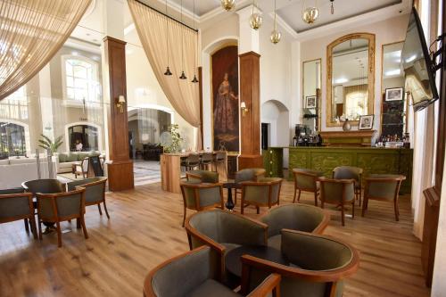 a restaurant with chairs and tables and a mirror at Plaza Camelinas Hotel in Querétaro