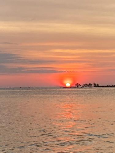 a sunset over the ocean with the sun setting at P Vacation Libong in Ko Libong