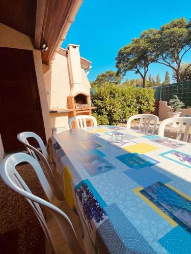 une table et des chaises sur une terrasse avec une table en mosaïque dans l'établissement VIAS PLAGE - Villa climatisee 5 pers proche plage avec terrasse et parking V0387, à Vias