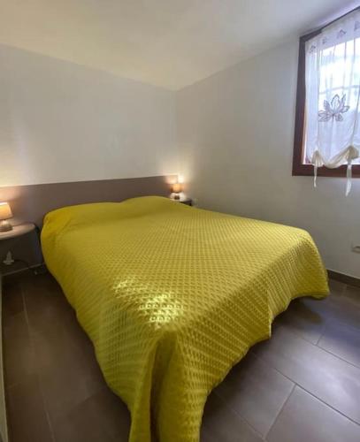 - une chambre avec un lit jaune et une couverture jaune dans l'établissement VIAS PLAGE - Villa climatisee 5 pers proche plage avec terrasse et parking V0387, à Vias