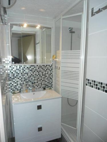 une salle de bain blanche avec un lavabo et une douche dans l'établissement VIAS PLAGE - Villa climatisee 5 pers proche plage avec terrasse et parking V0387, à Vias