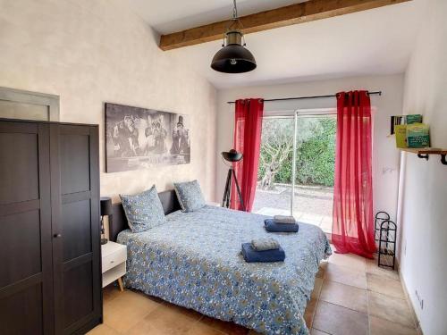 une chambre avec un lit et une fenêtre avec des rideaux rouges dans l'établissement La Cigotà - Villa with swimming pool for 8 people, à Pouzols-Minervois
