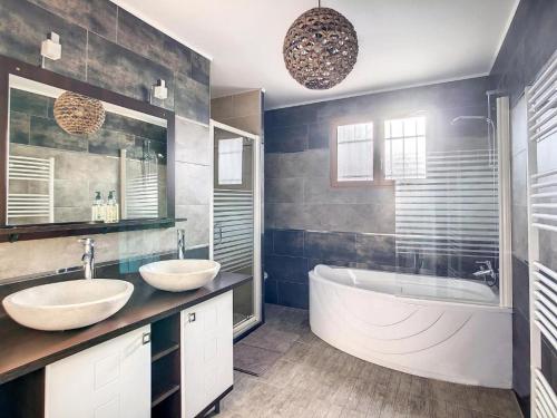 une salle de bain avec deux lavabos et une baignoire dans l'établissement La Cigotà - Villa with swimming pool for 8 people, à Pouzols-Minervois
