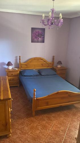a bedroom with a wooden bed and a chandelier at Casa Hontoba in Hontoba