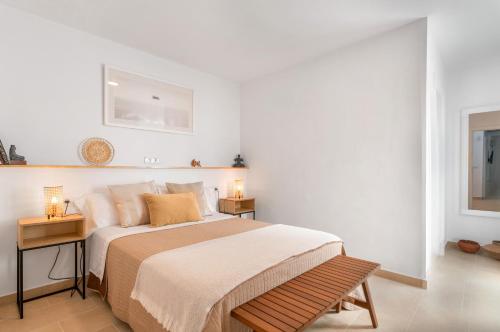 a white bedroom with a bed and two night stands at Casa Fela in Famara