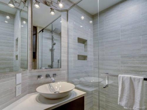 a bathroom with a sink and a glass shower at Charming Condo in the Mont Tremblant Ski Village in Mont-Tremblant