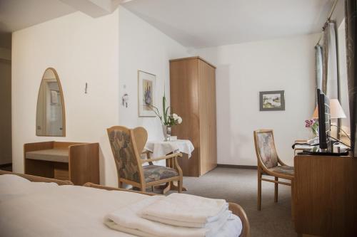 ウンナにあるAkzent Hotel Gut Höingのベッドとテーブルと椅子のあるホテルの部屋