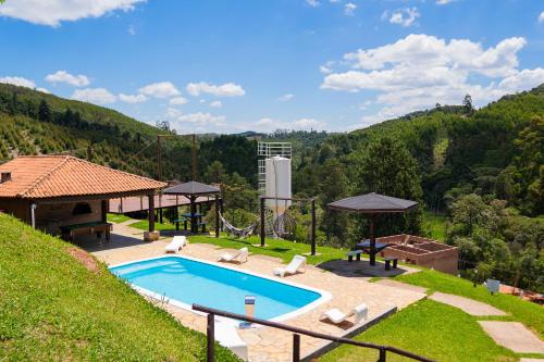 una piscina in un cortile vicino a una collina di Pousada Natureza da Terra a Monte Verde