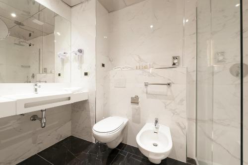 a bathroom with a toilet and a sink and a shower at Best Western Hotel Quattrotorri in Perugia